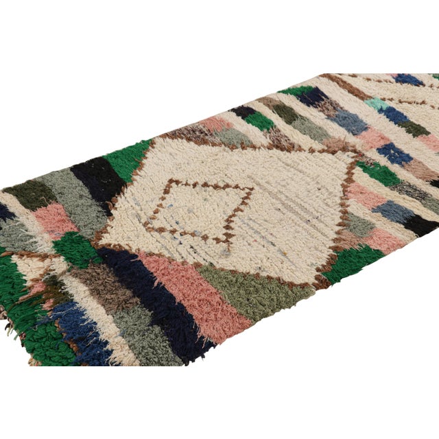 Hand-knotted in wool and originating from Morocco circa 1950-1960, this 3x7 vintage Moroccan rug is an extremely rare...