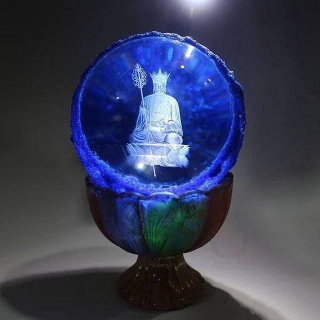 This is a rare and unusual Buddhist relic sphere, described as a "regenerated sarira" containing an etched image of a...