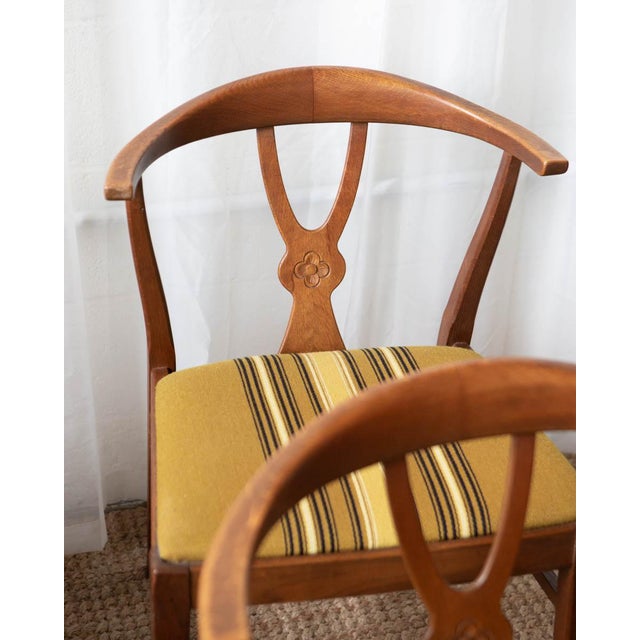 A striking set of four Danish dining chairs from the 1970s, crafted with solid walnut frames and beautifully carved...