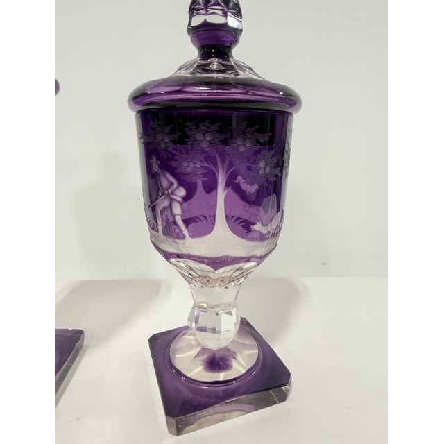 Near Pair Of Bohemian Amethyst Engraved Glass Covered Urns, Late 19th Century This finely matched pair of covered urns is...