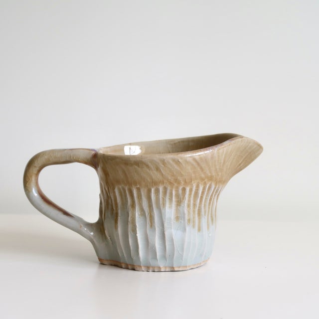 Handmade studio pottery creamer or small pitcher featuring an organically sculpted silhouette with a softly asymmetrical...