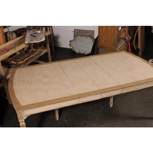 A vintage American painted wood dining room with leaves. This wooden table has a rectangular-shaped top that has a subtle...