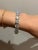 A Synthetic Moissanite Line Bracelet, with 17 round synthetic Moissanites claw set in sterling silver. 17 x 5ct RBC...