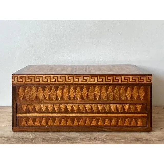 This exquisite vintage storage box captivates with its intricate marquetry work, showcasing a fascinating fusion of...