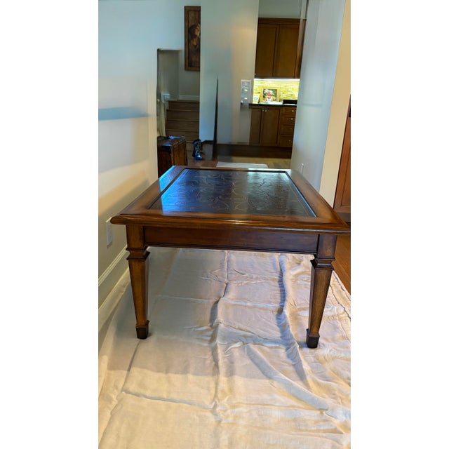 This handsome coffee table, in the style of Theodore Alexander, was purchased new in the late 1990s, has an inlaid, etched...