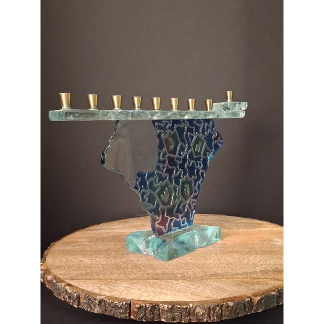 This studio art glass Hanukkah menorah features a sculptural, dreidel-shaped main panel crafted from heavy fused and...