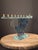 This studio art glass Hanukkah menorah features a sculptural, dreidel-shaped main panel crafted from heavy fused and...