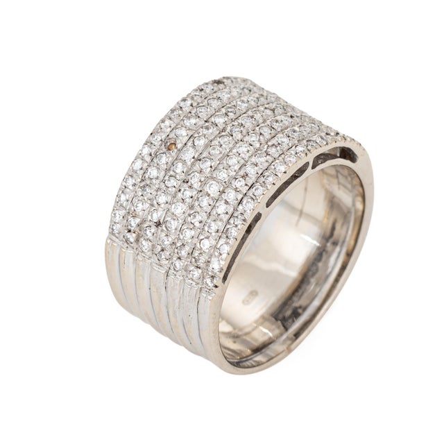 Stylish vintage diamond wide band crafted in 19k white gold (circa 1980s). Round brilliant cut diamonds total an estimated...