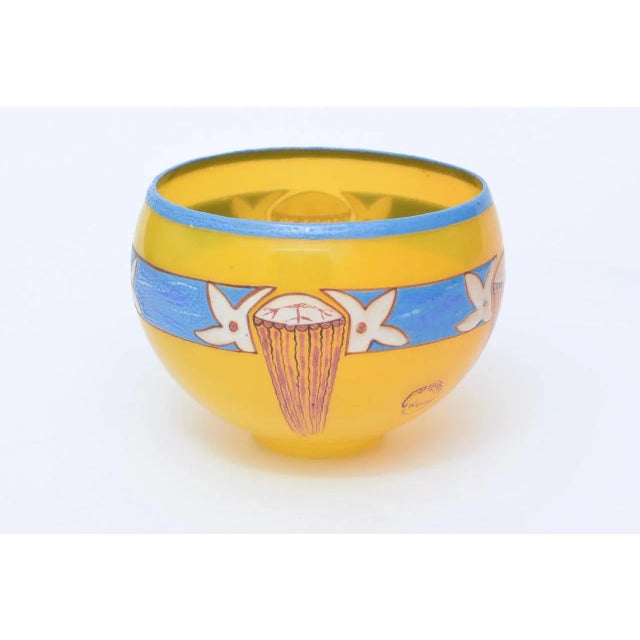 This lovely, small and obscure hand blown glass bowl by French artist: Andre Delatte has vivid colors of yellow, sky blue...
