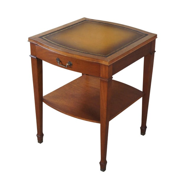 Mid 20th Century mahogany side or end table. Features a traditional Sheraton style form with a serpentine tooled leather...