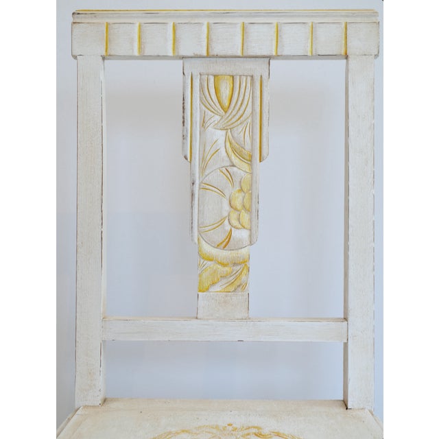This Art Deco chair, crafted from wood, is painted in a patinated white, enhanced with delicate touches of golden yellow...