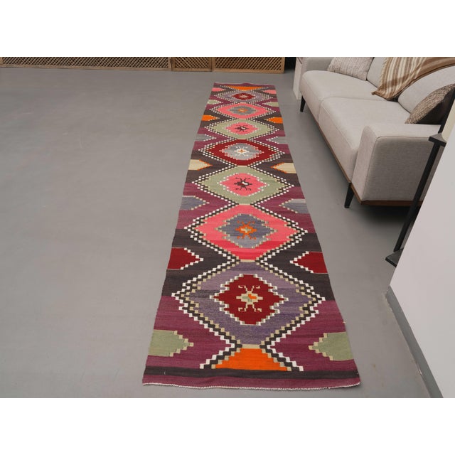 Vintage Hand-Knotted runner rug is a semi-antique vintage area rug. The '70s Eastern region of Anatolia's unique rug is...