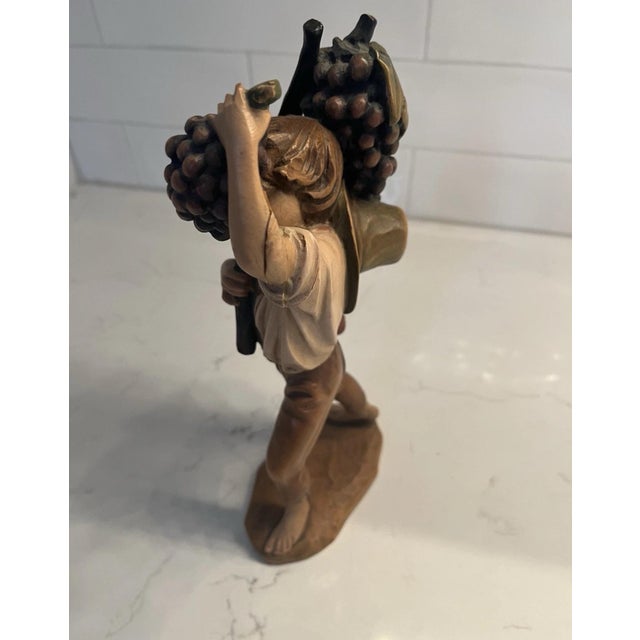 The product is a hand-carved wooden figurine of a boy eating grapes. Made by hand in Oberammergau, Germany by Anri. This...