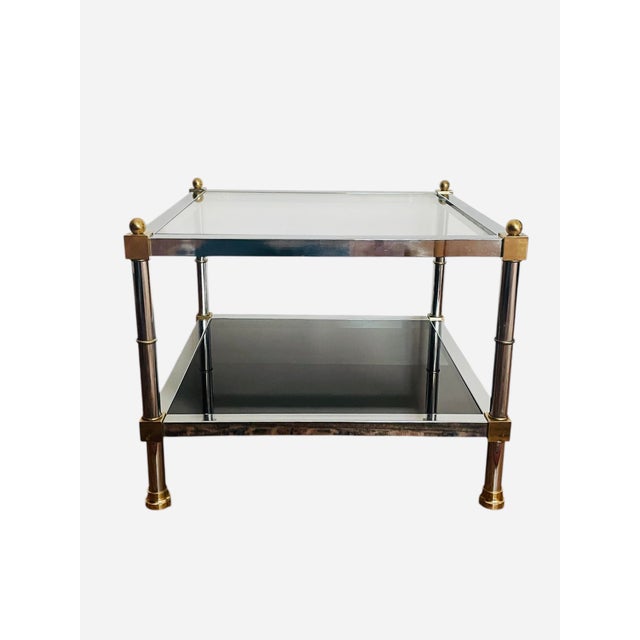 Stunning vintage chrome and brass coffee table. Designed in the 1980s. Offers a clear glass top and smoke glass base. They...