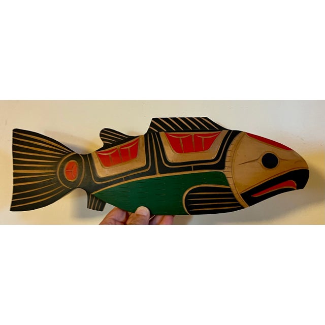 Squamish Nation carved wood and paint decorated salmon fish by Neil Baker. Relief carved with highly stylized detail....