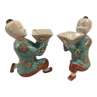 Pair of Porcelain Kneeling Chinese Boys Holding Shallow Single Blossom Vessels For Sale