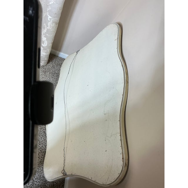 Vintage gold gilt French-style wall mirror featuring an elegant curved silhouette and decorative shell crest. The softly...