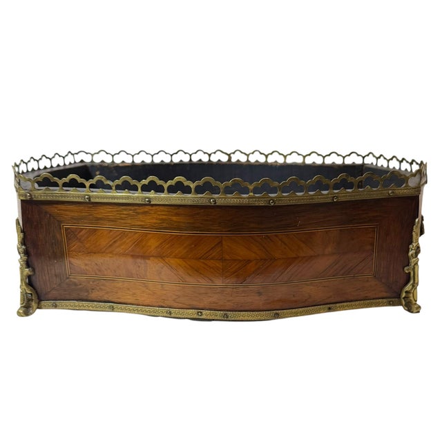 An exquisite 19th century Napoleon III marquetry jardinière featuring an elegant combination of maple, mahogany, and...