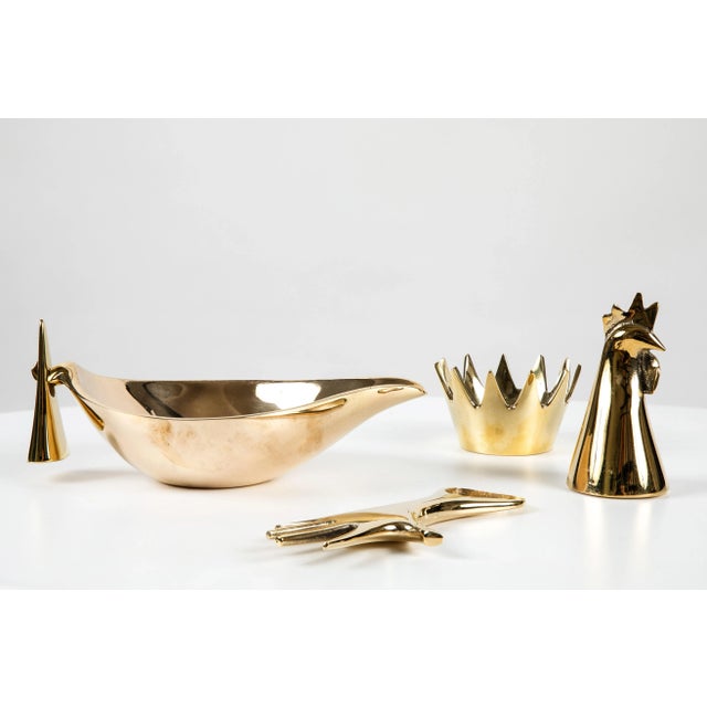 Set of four Carl Auböck brass objects. Includes Carl Aubock model #4272-2 'Rooster' brass bell, model #3600 'Crown' brass...