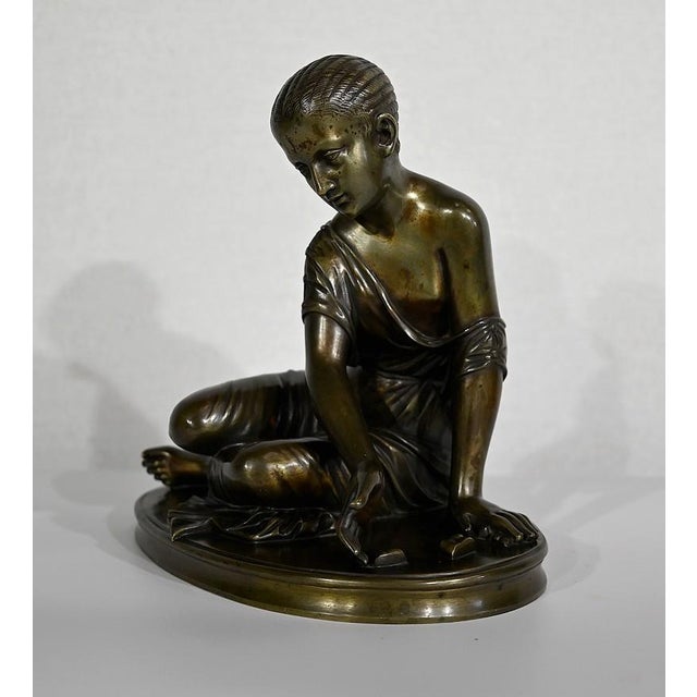 Ronze with a nuanced green patina entitled: "The bones player", reproducing the famous statue of ancient Rome of the same...