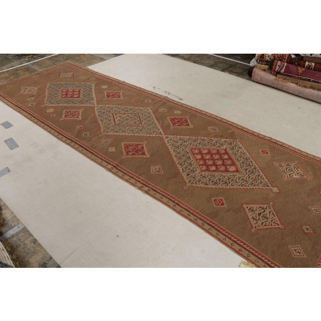 Originating from Persia in (year), this (antique/vintage) hand knotted wool Senneh Persian kilim hosts a perfectly...