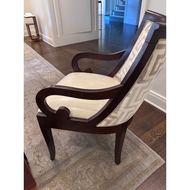 Elegant pair of custom-made transitional accent chairs featuring sculptural scroll arms, rich dark mahogany-tone wood...