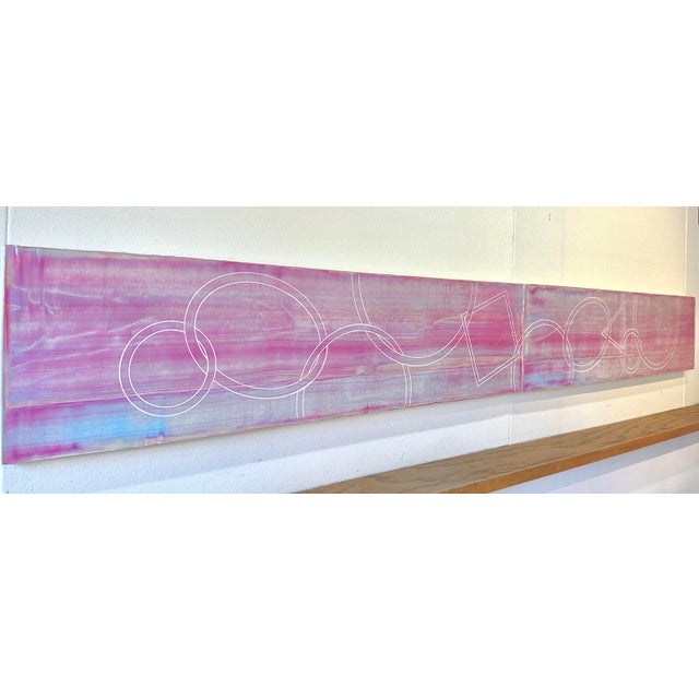A striking two-panel diptych stretching 96 inches wide, its surface built in Koury's interference paint so the soft pink...