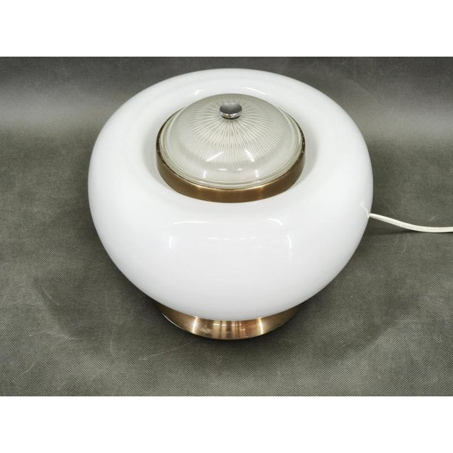 Sculptural italian glass table lamp from the 1970s, distinguished by its rounded white opaline glass body, textured clear...