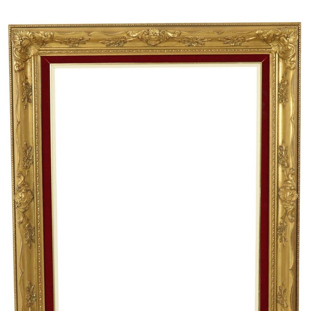 Large gilded vintage pine frame with a red velvet lining on the inside, entirely in classic Baroque style, decorated with...