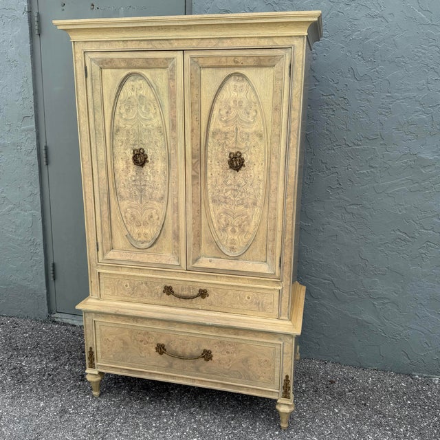 Elegant vintage French Provincial armoire by Detroit Furniture, featuring a softly distressed cream finish with...