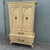 Elegant vintage French Provincial armoire by Detroit Furniture, featuring a softly distressed cream finish with...