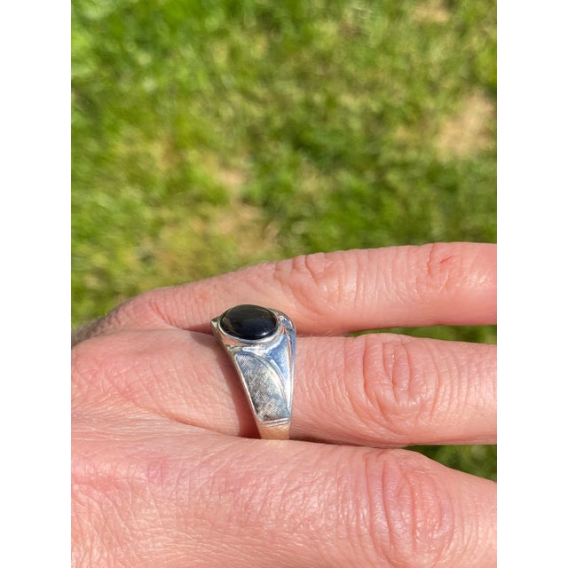 The Cascorro: Gentlemen's 14K Black Star Sapphire and Diamond Ring. Crafted in 14 karat white gold, this men's ring...