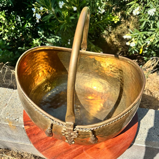 Large vintage hammered solid brass decorative basket with ornate rope and tassel accents and a movable curved handle....