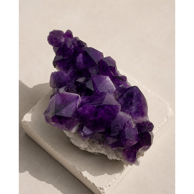 A substantial natural Uruguayan amethyst specimen selected for its deep violet crystal points, raw geological surface, and...