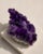A substantial natural Uruguayan amethyst specimen selected for its deep violet crystal points, raw geological surface, and...