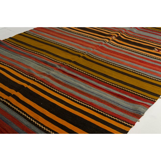 This is a vintage Turkish Oushak rug from the Mid 20th Century. The piece was hand-knotted.