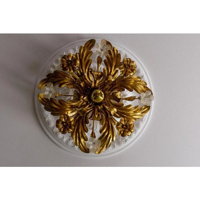 Italian Hollywood Regency style gilt metal and glass flower ceiling light, 1970s A charming Italian ceiling light in the...