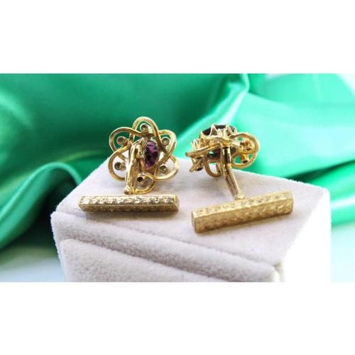 Gold cufflinks in the shape of flowers with onyx in the center and twelve (12) brilliant-cut diamonds. Metal: Gold....