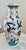 Vintage hand-painted Chinese porcelain dragon vase featuring colorful dragons and gilt accents against a white background....