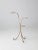 Vintage white iron ring plant stand with a slender, curving form. The openwork structure features three circular rings...