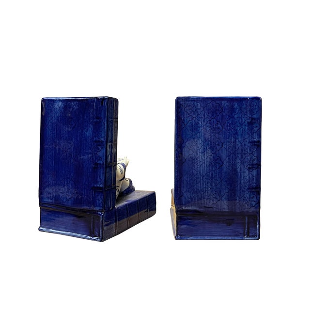 Handmade porcelain blue and white color Chinese style bookend with kids reading book figure. This bookend stopper is a...