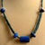 Distinctive beaded necklace handcrafted with striking deep blue lapis lazuli and cylindrical green serpentine. The center...