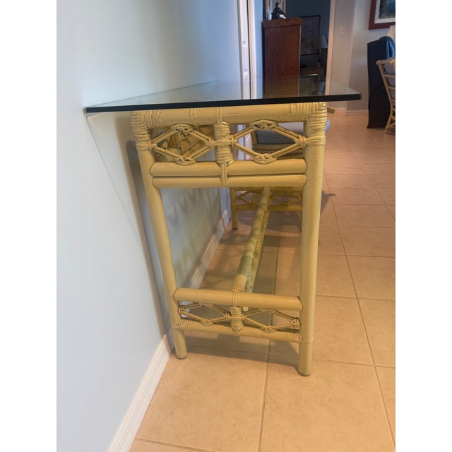 The console table was purchased in 1986. Ficks Reed distressed pineapple bamboo tempered glass top table comes from a set...