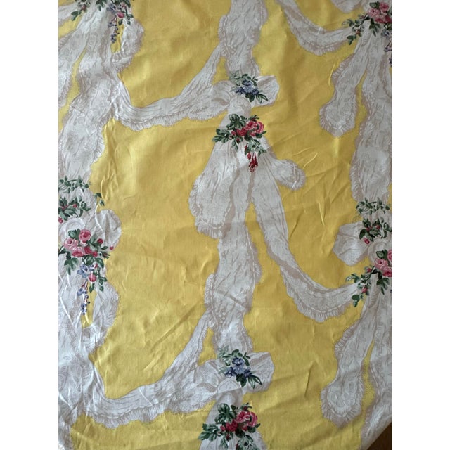 Vintage Rose Cumming “Lace” chintz fabric in a rich yellow ground with trompe-l’oeil lace swags and floral bouquets. A...