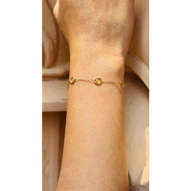 This is part of Chairish’s Fine Jewelry assortment. This Delicate Yellow Sapphire Stacking Chain Bracelet in 14K gold...