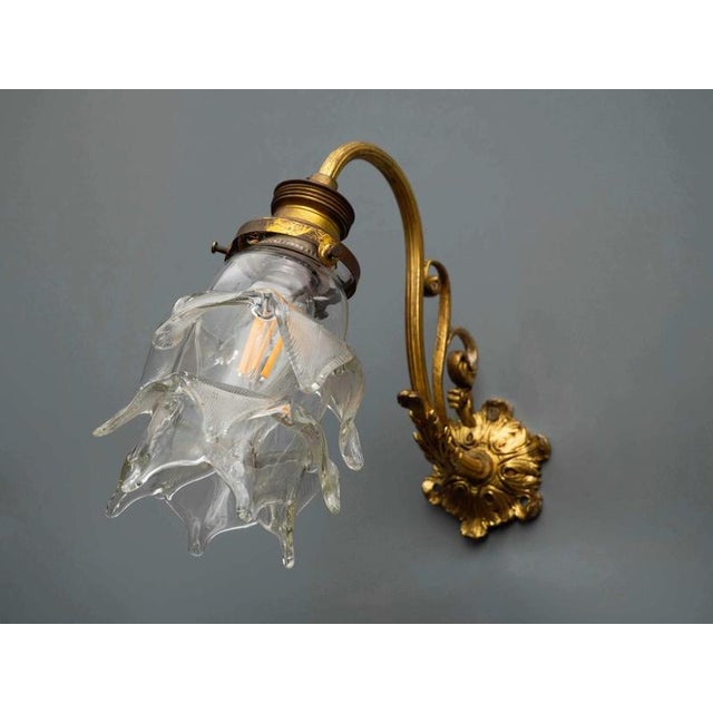 This luxurious wall lamp, made around 1900, is an elegant piece of lighting that will impress with its historical value...
