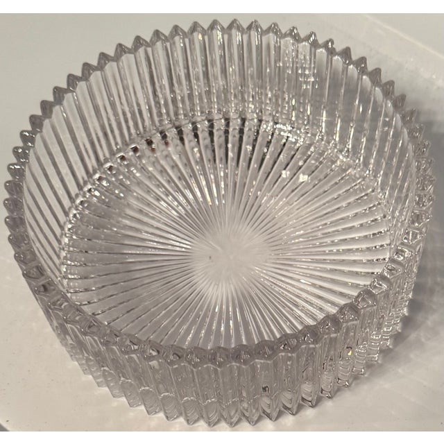 Vintage clear glass serving bowl featuring a striking ribbed design with a radiating sunburst base. The bold vertical...