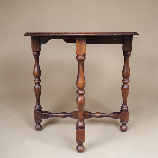 Early 20th century Dutch oak occasional table featuring a circular top over turned legs joined by a decorative stretcher...