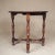 Early 20th century Dutch oak occasional table featuring a circular top over turned legs joined by a decorative stretcher...