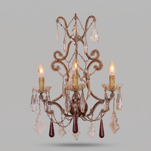 A pair of three-light wall sconces in the Louis XV style, made in the 20th century, probably in the first half. The...